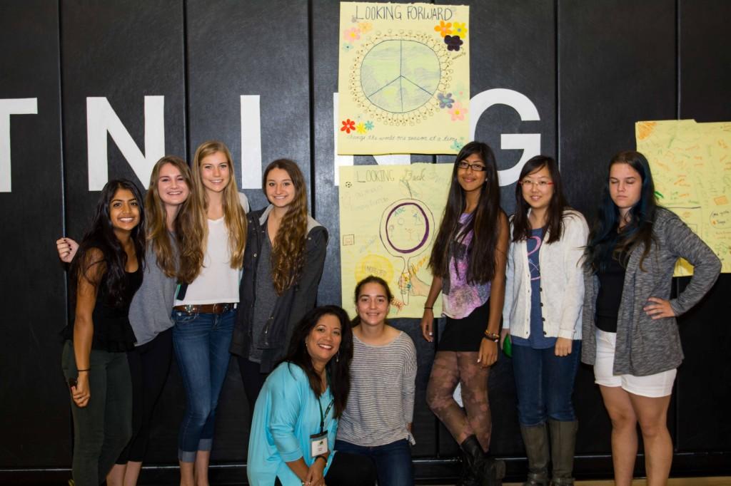 Juniors Amira Tarsadia, Meagan Gooding, Lauren Solaas, Isabelle Eckel, Claire Goul, Elizabeth Alvarez, Hannah Hong, and Paula Gardner (left to right) pose in front of their poster during Service Learning on Wednesday October 2, 2013. Photographer: Kellen Ochi