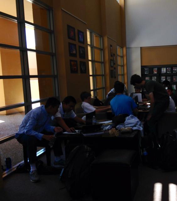 Students gather around their laptops in the library. April 15 2014. Photographer: Claire Goul.