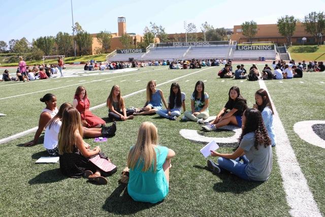 A freshman advisory group sits on Ramer Field and gets to know each other during New Student Orientation Aug. 21.
