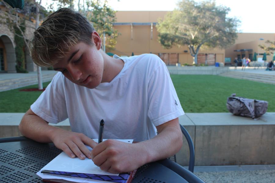 Sophomore Cole Mitchell writes notes in Town Square.