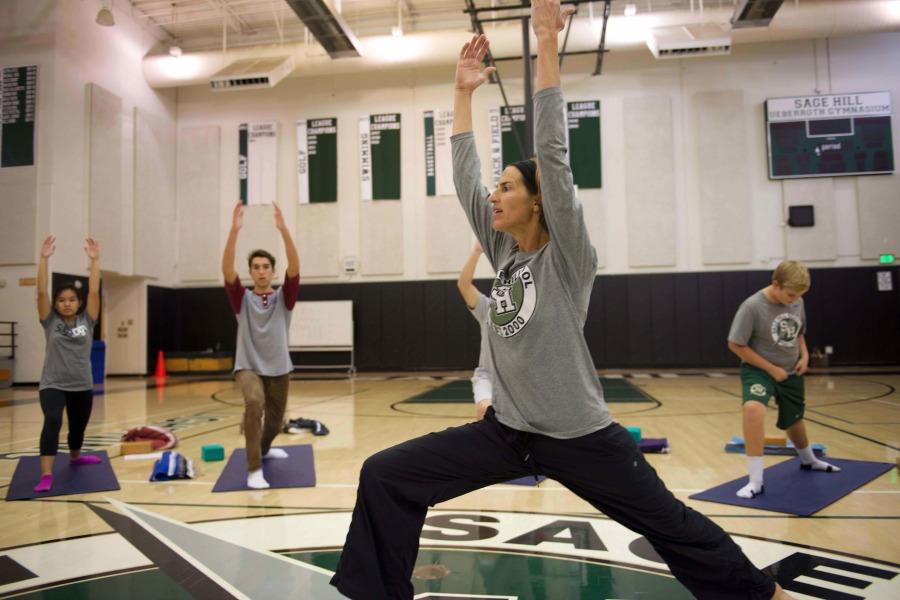 Connolly leads her yoga students in a warrior pose stretch.