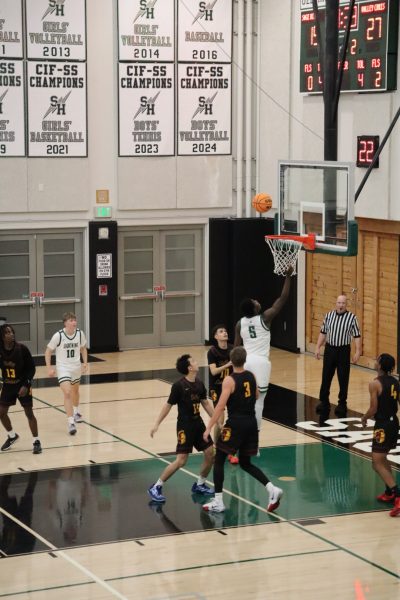 Sophomore Timi Akomolafe (5) flies toward the net against Valley Christian on Dec. 3.