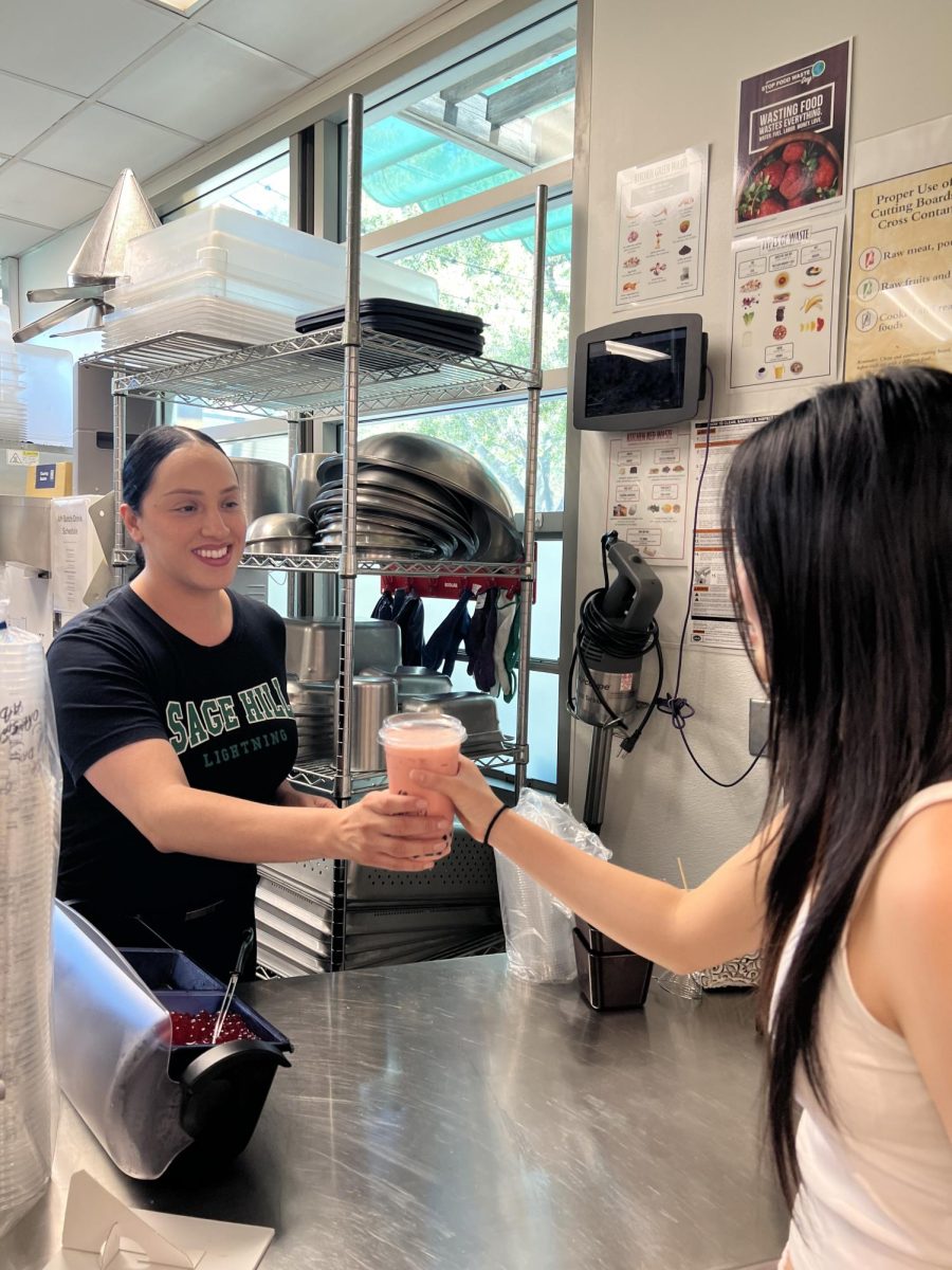 FLIK staff member Zuleyma Aguilar serves a strawberry milk tea to sophomore Lindsey Lee.